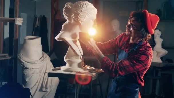 Manlig skulptör tittar på gips byst efter borsta den — Stockvideo
