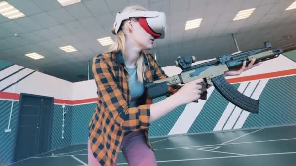 Μια γυναίκα παίζει ένα παιχνίδι εικονικής πραγματικότητας με ψεύτικο όπλο. Εικονική έννοια βιντεοπαιχνιδιών πραγματικότητας. Παιχνίδι VR, έννοια επαυξημένης πραγματικότητας. — Αρχείο Βίντεο