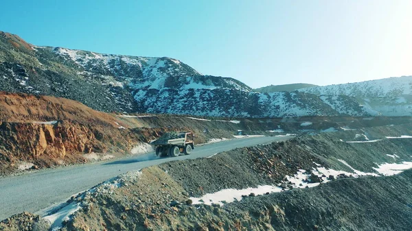 Yüklü kamyon bir maden sahasının karlı yollarında ilerliyor.