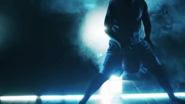 Karanlıkta basketbol topu atan bir sporcunun yavaş çekimi.