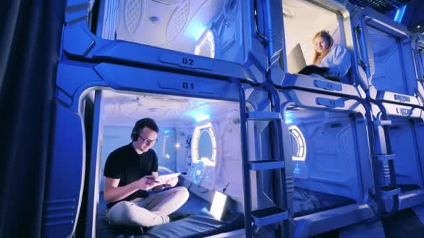 Capsule hotel rooms with young people having a rest — Stock Video