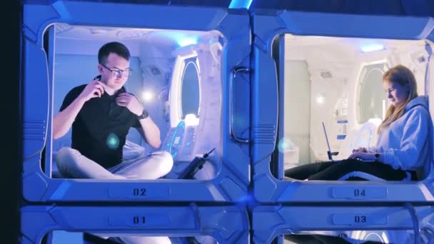 A guy and a girl in adjoined units of a capsule hotel — Stock Video