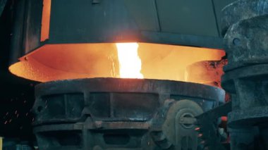 Erimiş metal büyük bir konteynıra dökülüyor. Metalürji fabrikası ekipmanları, metalurji endüstrisi konsepti.