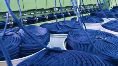 Mavi iplik yığınları mekanik olarak çözülüyor.