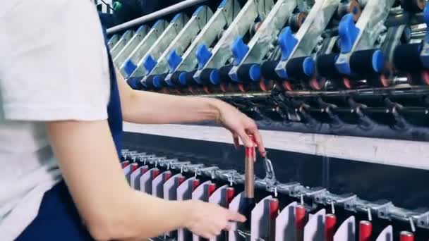 Rollen mit Fäden werden von einem Textilarbeiter eingestellt — Stockvideo