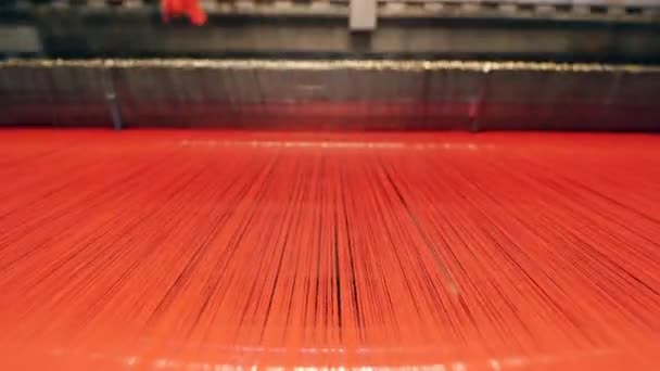 Rode draden worden gebruikt door een fabrieksmechanisme voor weven. — Stockvideo