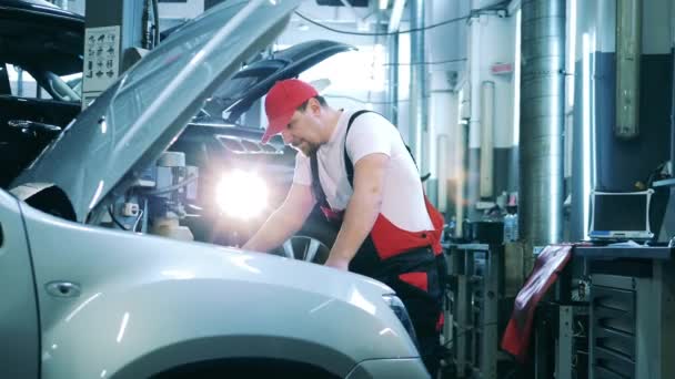 Meccanico automatico lavora su un'auto in una officina di riparazione — Video Stock