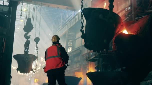 Metallurgical factory interior. Metallurgical plant unit with a steel worker in protection wear — Stock Video