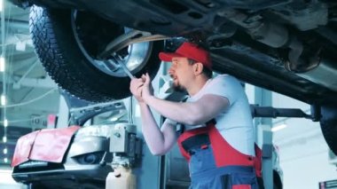 Uzman, araba tekerleğini sıkmak için İngiliz anahtarı kullanıyor.