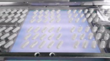Taşıyıcı boyunca hareket eden kapsül haplı kabarcıklar. İlaç fabrikası üretim hattı.