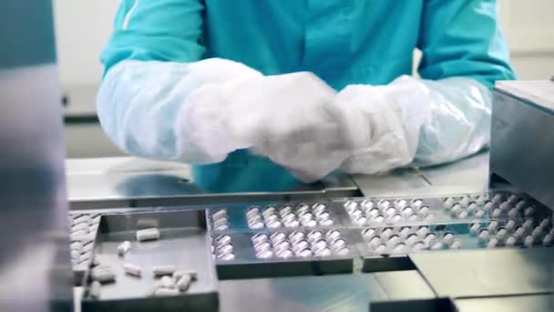 Farmacologo sta sostituendo le capsule sul nastro trasportatore. Linea di produzione di fabbrica farmaceutica. — Video Stock