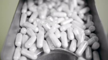 Kuru maddeli kapsüller taşıyıcı deliğe düşüyor. İlaç fabrikası üretim hattı.