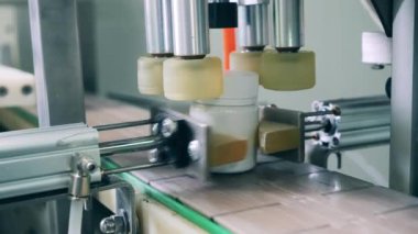 Küçük küvetler endüstriyel bir makine tarafından kapatılıyor.