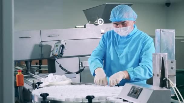 El farmacólogo masculino está poniendo tinas de plástico en el transportador — Vídeo de stock