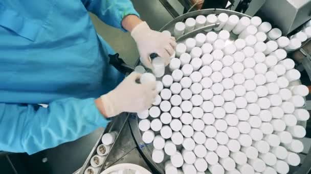 Línea de producción de fábrica farmacéutica. Las tinas de la píldora son reubicadas en el transportador por un farmacólogo — Vídeos de Stock