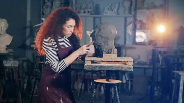 Doamna sculptor folosește un zgârie-nori în timp ce lucrează cu lut — Videoclip de stoc