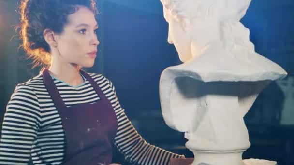Lady kunstenaar gebruikt een borstel om het beeldhouwoppervlak schoon te maken — Stockvideo