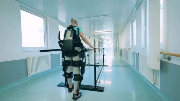 Hospital con una mujer entrenando caminando en el exoesqueleto — Vídeo de stock