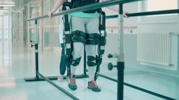 Un patient en exosquelette est assisté par un médecin tout en marchant — Video