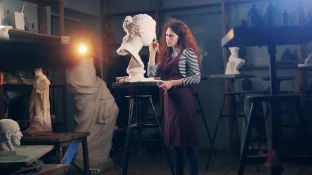 Художественная студия с женщиной-скульптором, работающей над бюстом. Творчество, вдохновение, воображение. — стоковое видео