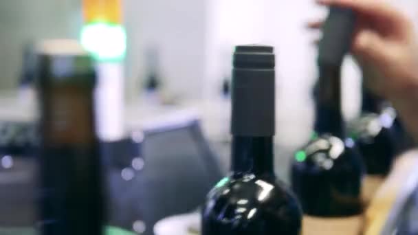 Nahaufnahme von Arbeitern, die Schraubverschlüsse auf Weinflaschen montieren — Stockvideo