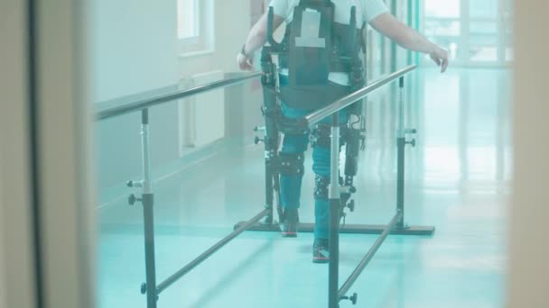 Un homme s'entraîne à marcher dans l'exosquelette dans un établissement médical — Video