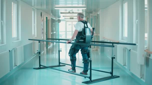 エクソスケルトンの男性患者は援助なしで歩くことを訓練しています — ストック動画