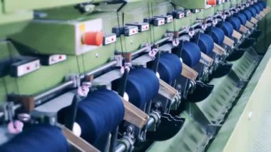 Fabrikada iplikli makaralar dönüyor.