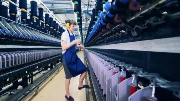 Unidad de fábrica textil con un empleado de planta que trabaja con hilos — Vídeo de stock