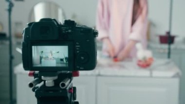 Kamera, sebze kesen bir bayanı çekiyor. Çevrimiçi vlog kavramı, kadın blogger kayıt videosu, çevrimiçi yayın kavramı.