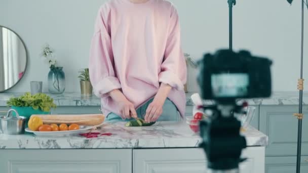 Відеокамера знімає жінку, яка ріже овочі — стокове відео