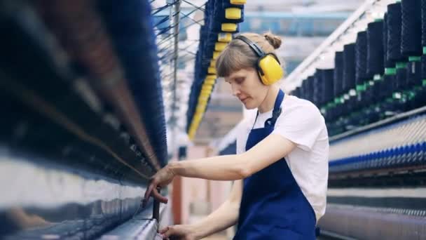 La trabajadora está quitando los hilos adicionales del equipo de fábrica — Vídeo de stock