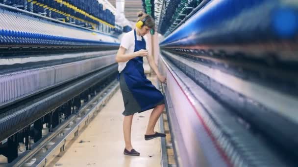 Trabajador de planta está ajustando los hilos en la unidad de fábrica textil — Vídeo de stock