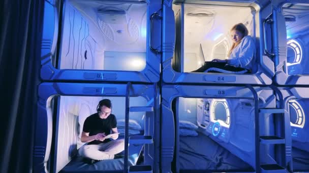 Camere di un capsule hotel con una ragazza e un giovane uomo all'interno — Video Stock