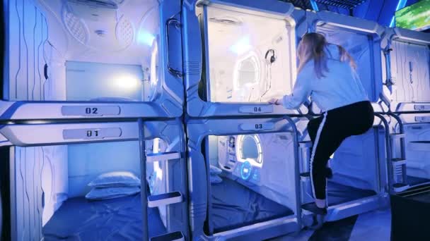 Una ragazza sta salendo nella stanza del capsule hotel — Video Stock