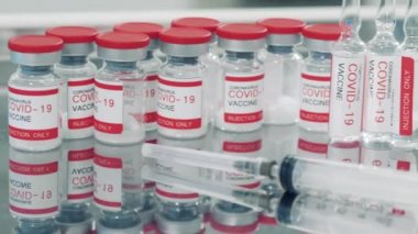 Yanında şırınga bulunan Covid-19 aşıları.