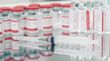 Şırınga ve covid 19 aşıları olan bir tıbbi masa.