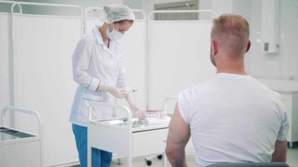 Kobieta lekarz wstrzykuje mężczyźnie szczepionkę przeciw koronawirusowi. — Wideo stockowe