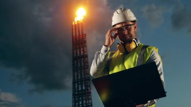 Oil refinery pipes with a male engineer standing near them. Oil industry, petrochemical factory, refinery concept. — Stock Video