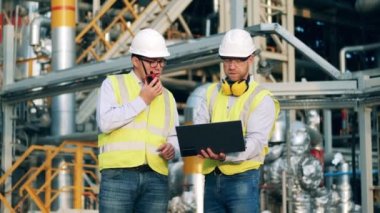 Mühendisler petrol rafineri tesisini tartışıyorlar.