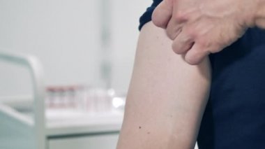 Erkek koluna aşı enjekte edilirken yakın çekim.