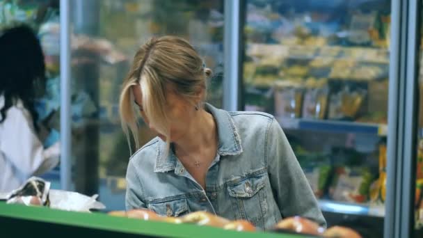 Mujer rubia está eligiendo juguetonamente frutas en el supermercado — Vídeos de Stock