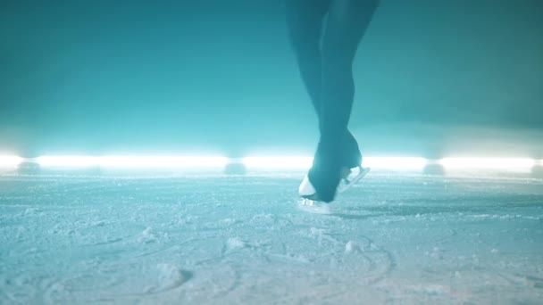 Powierzchnia lodu z nogi sportowców w łyżwach przędzenia na nim — Wideo stockowe