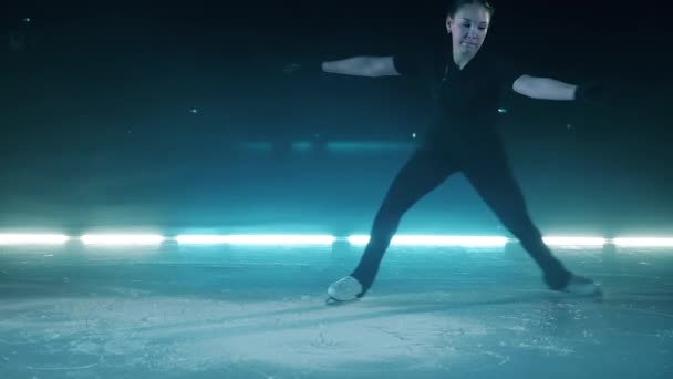 Mouvement lent d'une fille tournant dans une position tout en patinant — Video