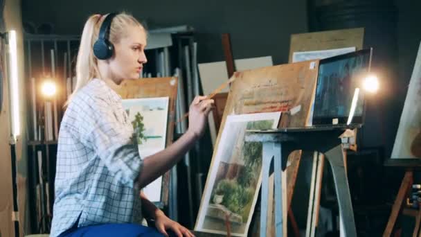 Una donna bionda sta facendo una lezione d'arte a distanza. Concetto di educazione artistica. — Video Stock