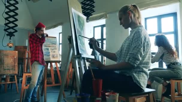 Un gruppo di donne sta facendo un corso d'arte con un pittore maschio. Concetto di educazione artistica. — Video Stock
