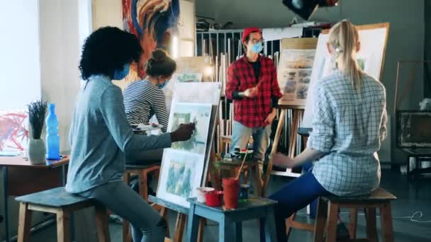艺术教育概念。戴面具的男画家正在为学生们举办一个绘画学习班 — 图库视频影像
