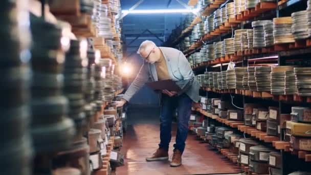A férfi archivista megőrzi a retro filmszalagok nyilvántartását. — Stock videók