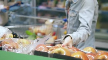 Süpermarket meyveleri toplanıyor. Bir kadın al.
