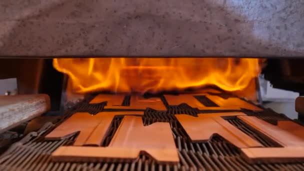 Furnace with a conveyor transporting copper pieces into it — Stock Video